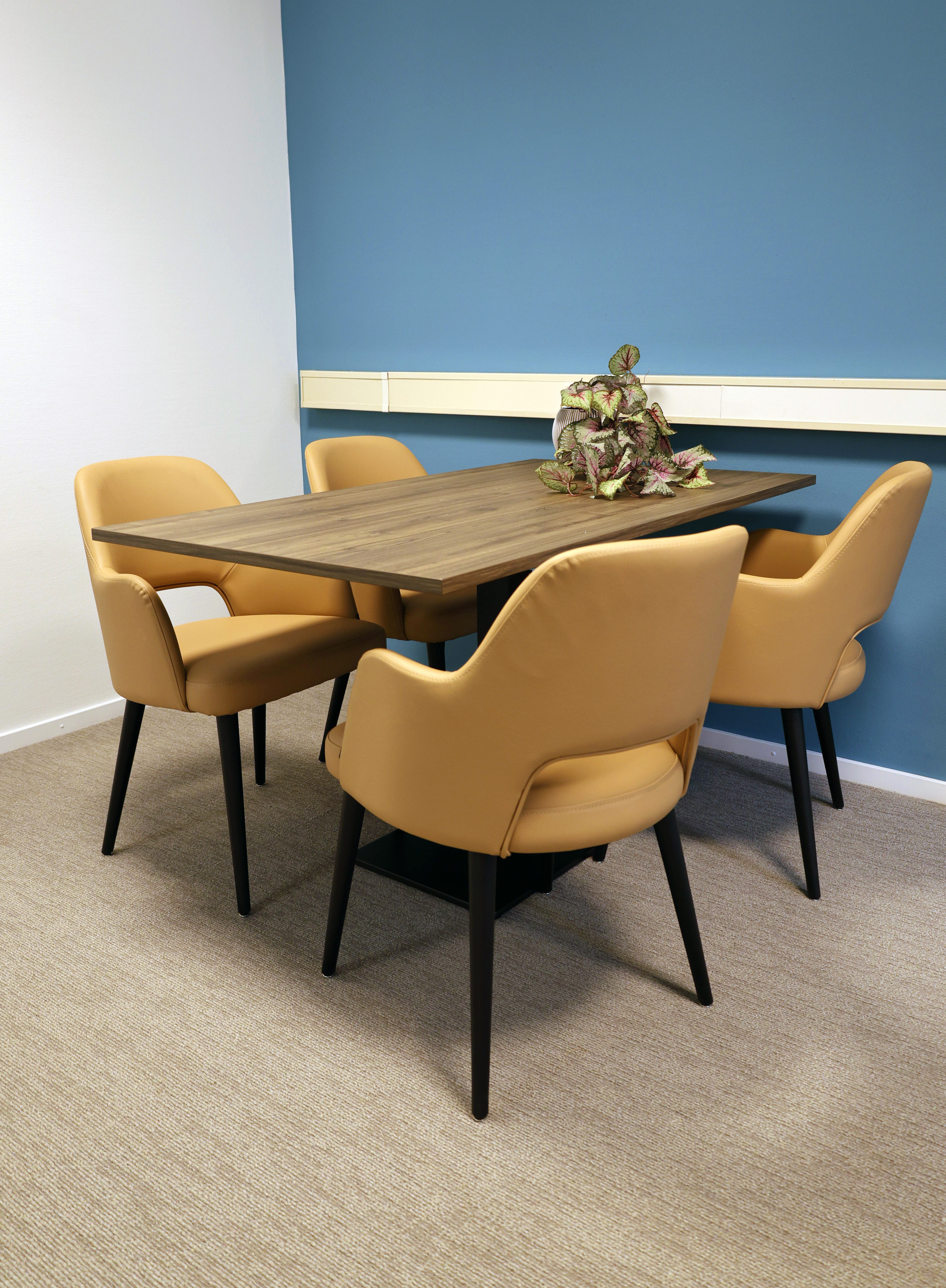 Lege tafel met gele stoelen in spreekkamer