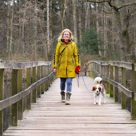 Vrouw wandelt met hond over brug