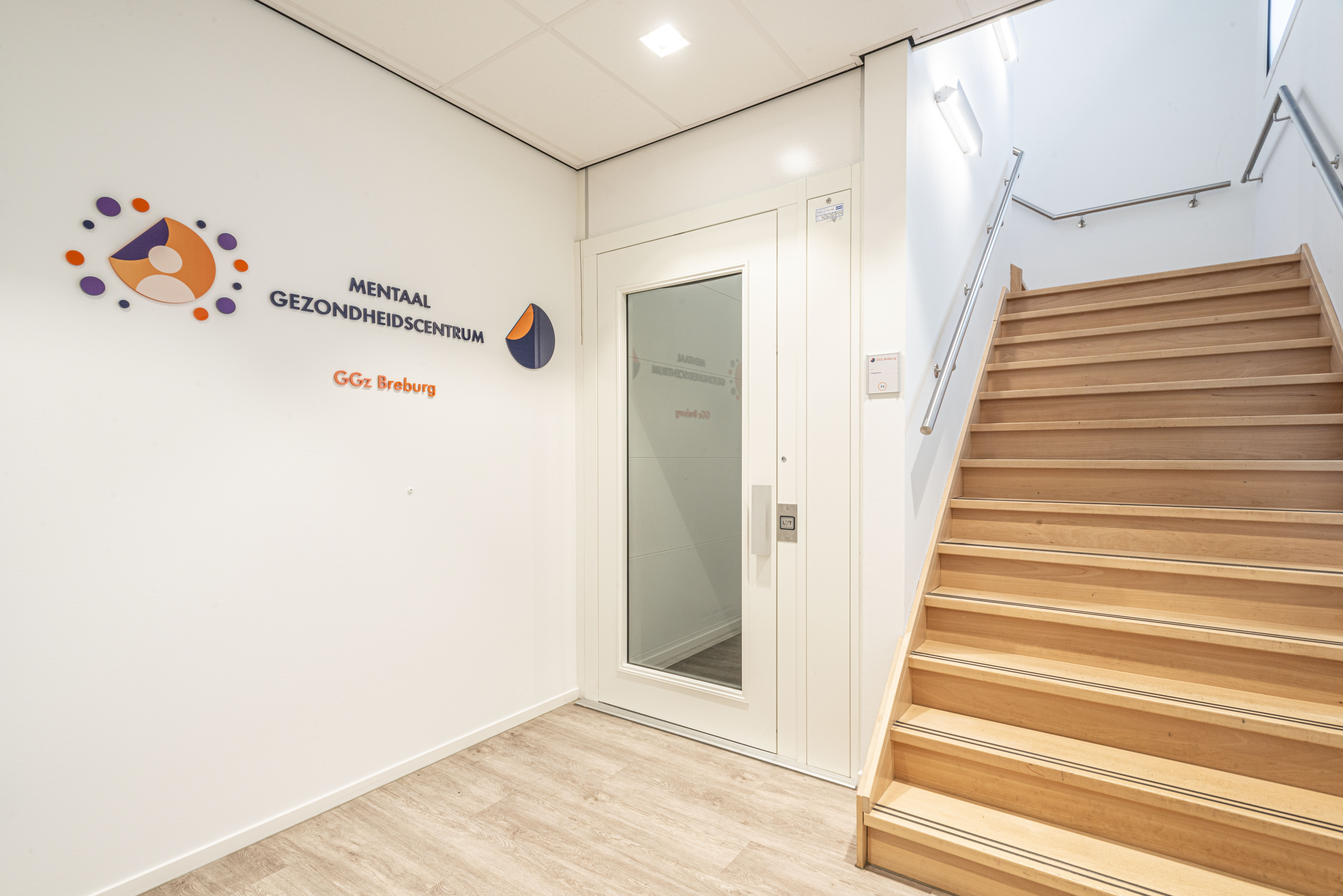 Trap en lift met op de muur de tekst Mentaal Gezondheidscentrum GGz Breburg