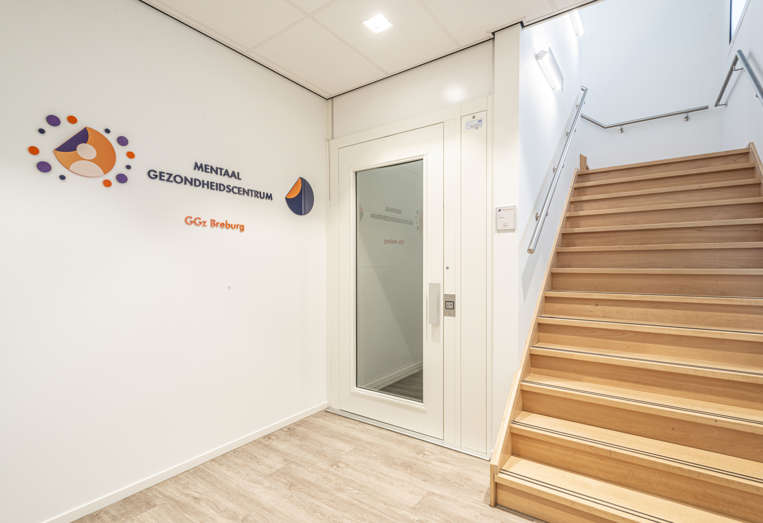 Trap en lift met op de muur de tekst Mentaal Gezondheidscentrum GGz Breburg