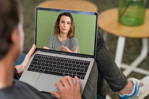 Vrouw te zien op videogesprek via laptop