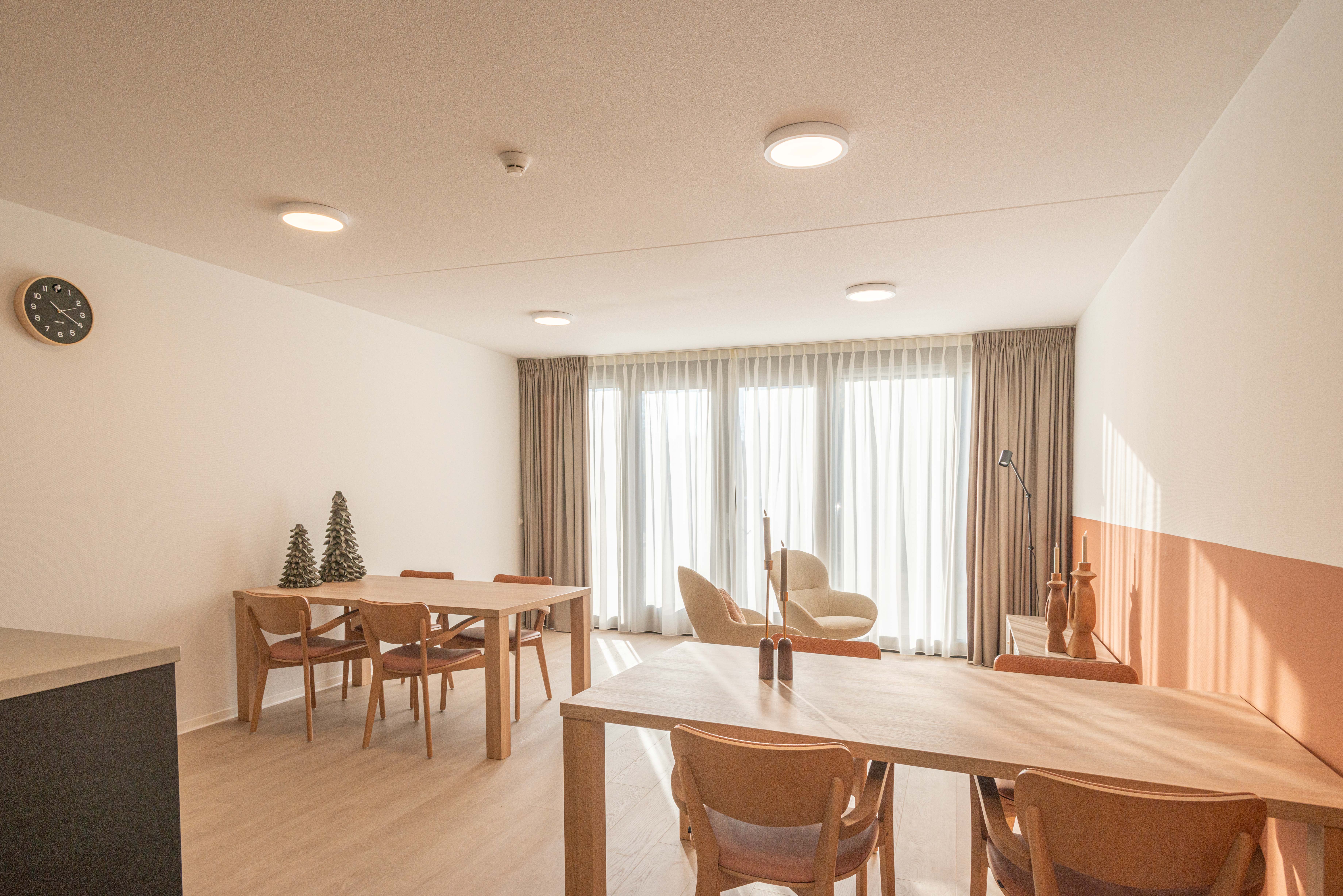 Interieur gemeenschappelijke ruimte Heuvelstraat Dongen met tafels en keukenblok